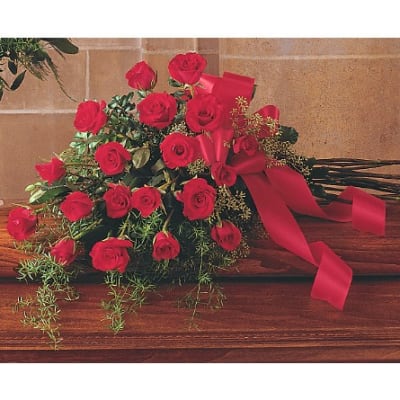 Bouquet of red roses with a red ribbon on a wooden surface