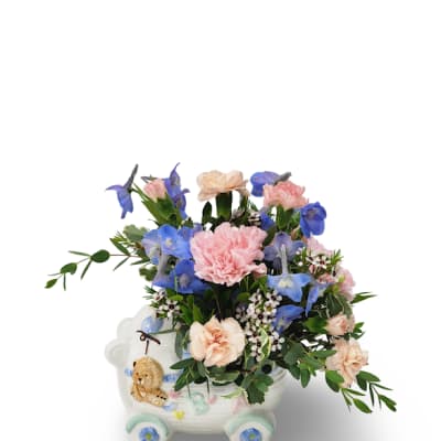 Pink and blue flowers arranged in a decorative ceramic cart