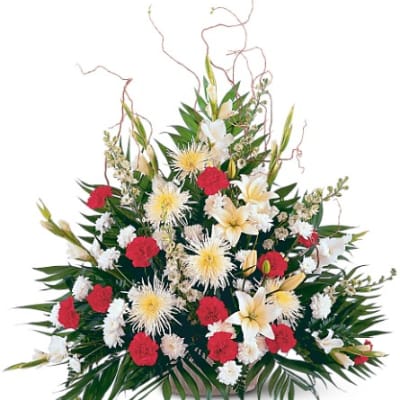 Large floral spray with white lilies, red carnations, and white spider mums