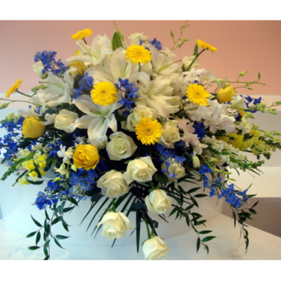 Large bouquet of white lilies, roses, and yellow daisies with blue accents