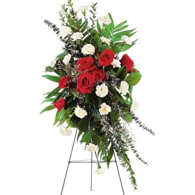 Standing floral spray with red roses and white carnations on an easel
