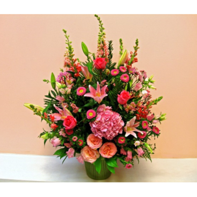 Pink and peach mixed flower arrangement in a green vase