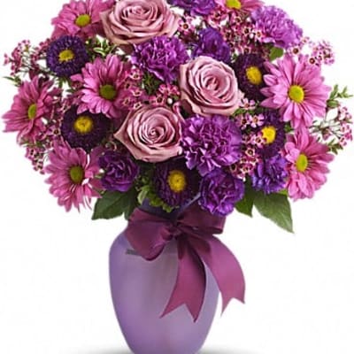 Purple and pink bouquet in a lavender vase with a ribbon