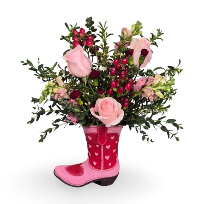 Pink roses and mixed flowers arranged in a pink cowboy boot