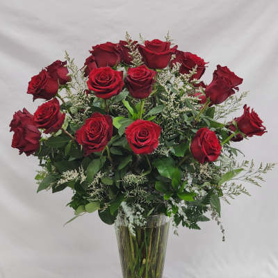 Red roses arranged in a clear glass vase