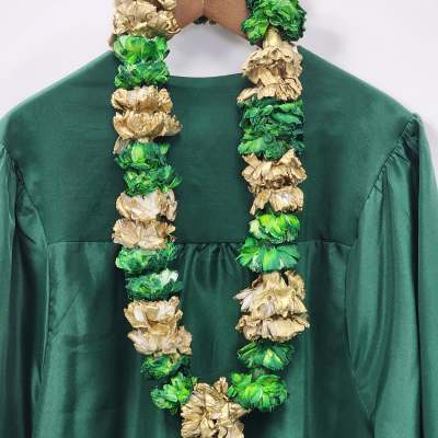 Green and gold floral lei draped over a dark green dress on a hanger
