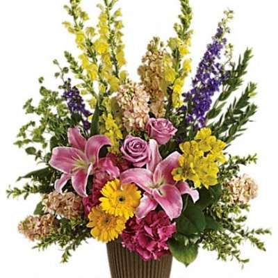 Mixed bouquet in a ribbed brown vase with pink lilies and yellow flowers