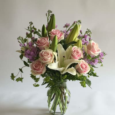 Pink roses and white lilies in a clear glass vase
