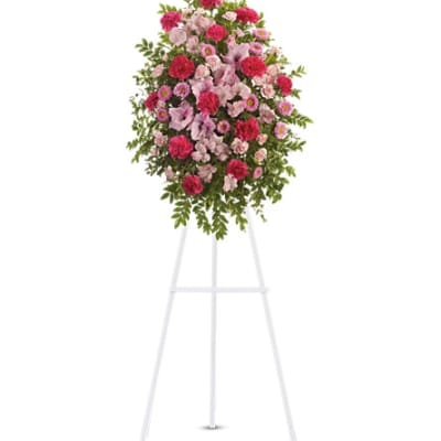 Pink and red floral standing spray on a white easel
