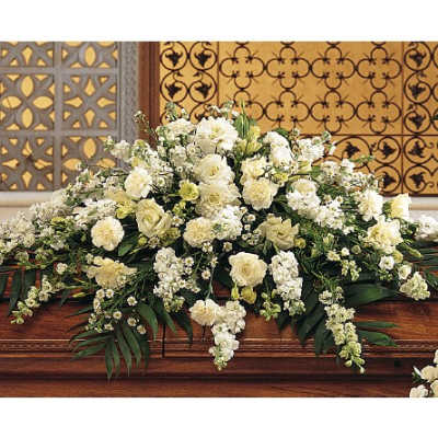 Large white floral arrangement on a wooden casket