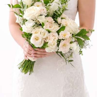 Bride holding a white bouquet of roses and calla lilies