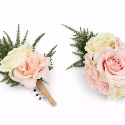 Two small rose boutonnieres with pale pink and cream blooms