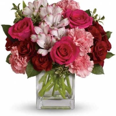 Bouquet of pink and red roses with white alstroemeria in a clear glass vase