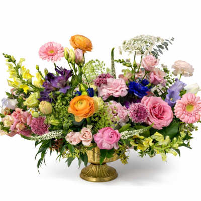 Colorful mixed flower arrangement in a gold pedestal vase