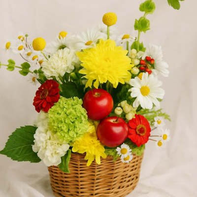 Basket arrangement with red apples and mixed flowers in yellow, white, red, and green