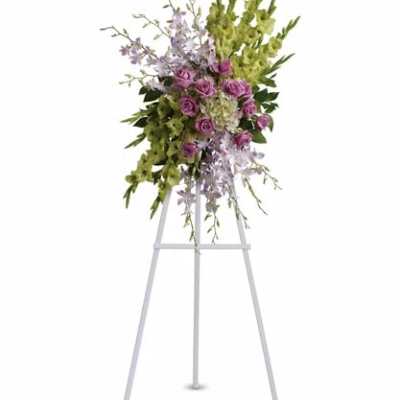 Standing floral spray with purple roses and green orchids on an easel