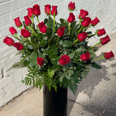 Red roses arranged in a tall black vase