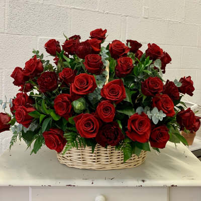 Basket of red roses with greenery