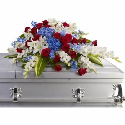 Red, white, and blue floral spray on a silver casket