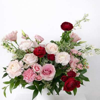 Pink and red rose arrangement in a white vase