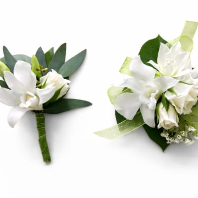White orchid boutonnieres with green ribbon and leaves