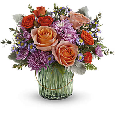 Bouquet of peach and orange roses with purple daisies in a glass vase