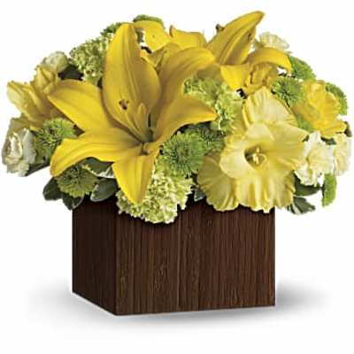 Yellow lilies and white flowers arranged in a square wooden container
