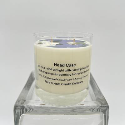 Cream-colored scented candle in a clear glass jar on a glass stand