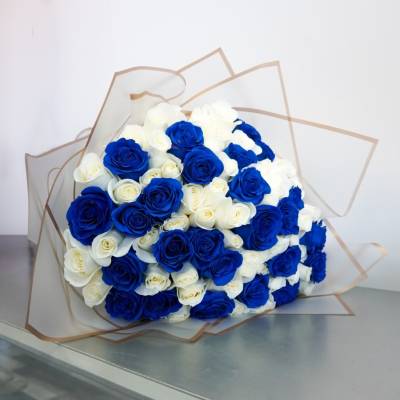 Bouquet of blue and white roses wrapped in clear paper