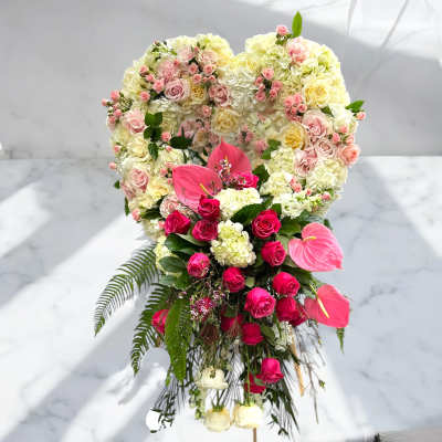 Heart-shaped floral arrangement with pink roses and white hydrangeas