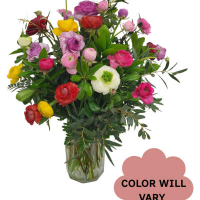 Mixed bouquet of colorful ranunculus in a glass vase