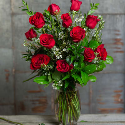 Red roses arranged in a clear glass vase