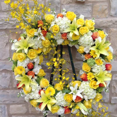 Yellow and white floral wreath on a black stand