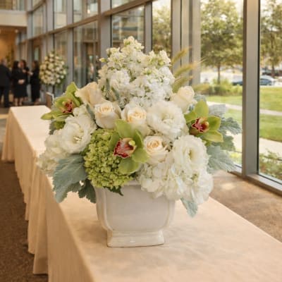 White floral centerpiece in a ceramic vase on a table