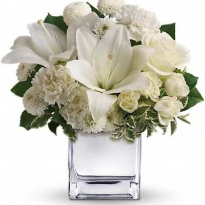 White floral arrangement in a clear square vase