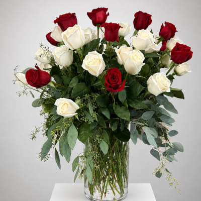 Red and white roses arranged in a clear glass vase