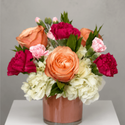Peach and pink flowers arranged in a glass vase