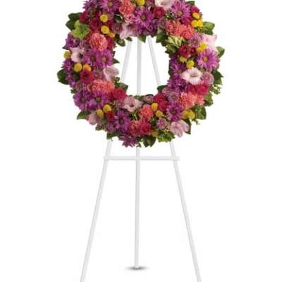 Colorful floral wreath on a white easel stand