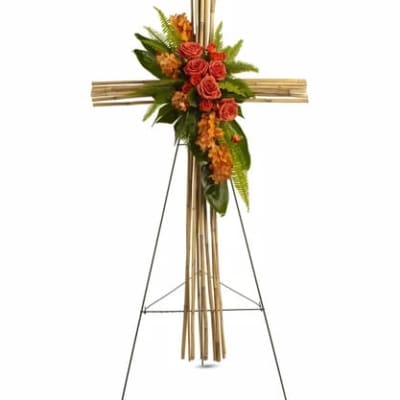 Floral cross on a metal stand with red roses and orange flowers