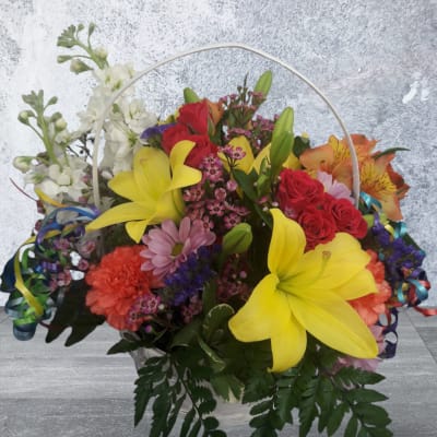 Colorful mixed flower basket with yellow lilies, red roses, and white blooms