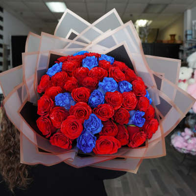 Bouquet of red and blue roses wrapped in layered paper