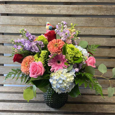 Mixed bouquet in a black vase with pink, purple, and coral flowers