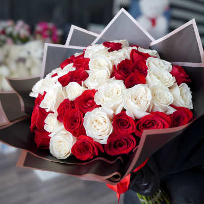 Bouquet of red and white roses wrapped in dark paper