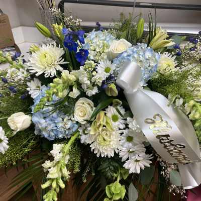 Large white and blue floral spray with a silver ribbon