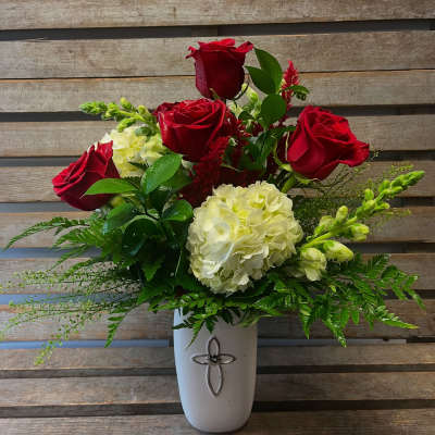 Red roses and white hydrangeas in a white vase