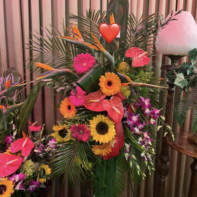 Tropical floral arrangement with sunflowers, gerbera daisies, and pink anthuriums