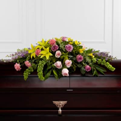 Colorful floral casket spray with yellow lilies and pink roses