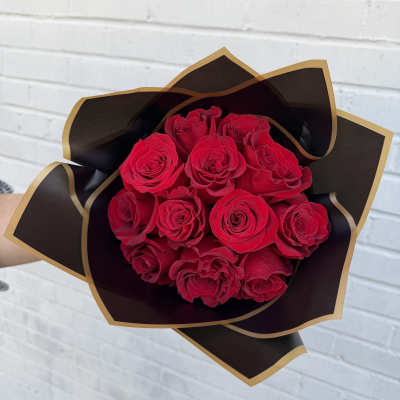 Bouquet of red roses wrapped in black and gold paper