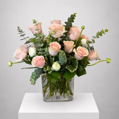Pink roses and white blooms in a clear glass vase