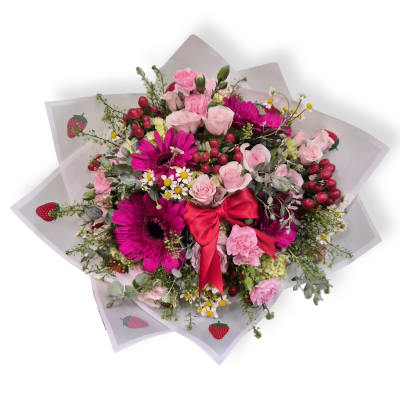 Bouquet of pink roses and magenta gerbera daisies with a red ribbon